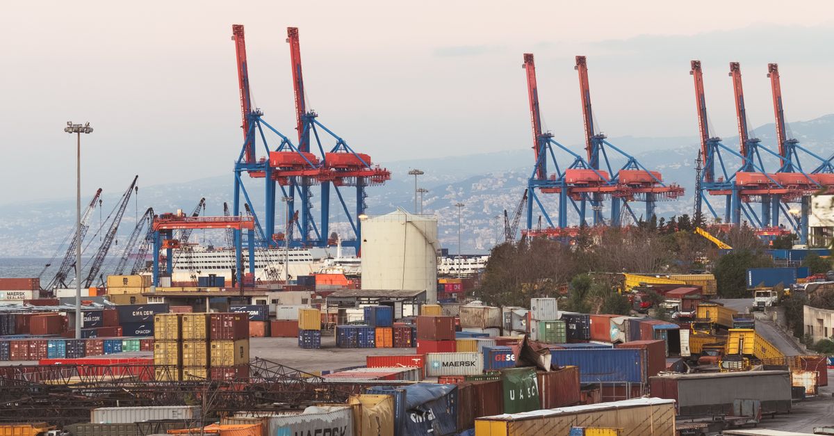A bustling industrial view of Beirut port with cargo containers and towering cranes.